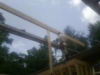 Carpenter setting a ridge beam over a new addition frame — Ice Dam Removal by Roofing Brothers in Myrtle Creek