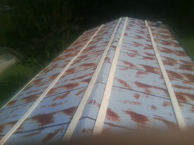 Rusted metal roof panels with new wood purlins before replacement — Storm Damage Roof Repair in Myrtle Creek by Roofing Brothers