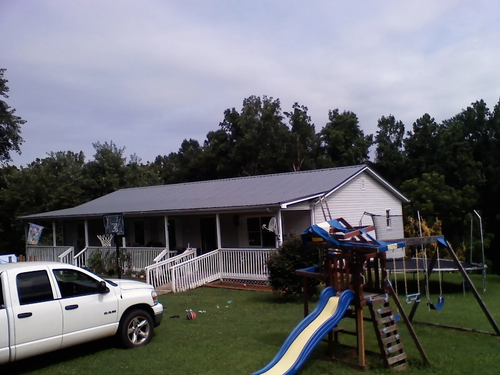 Dark metal roof on a country home with a full length front porch in Myrtle Creek