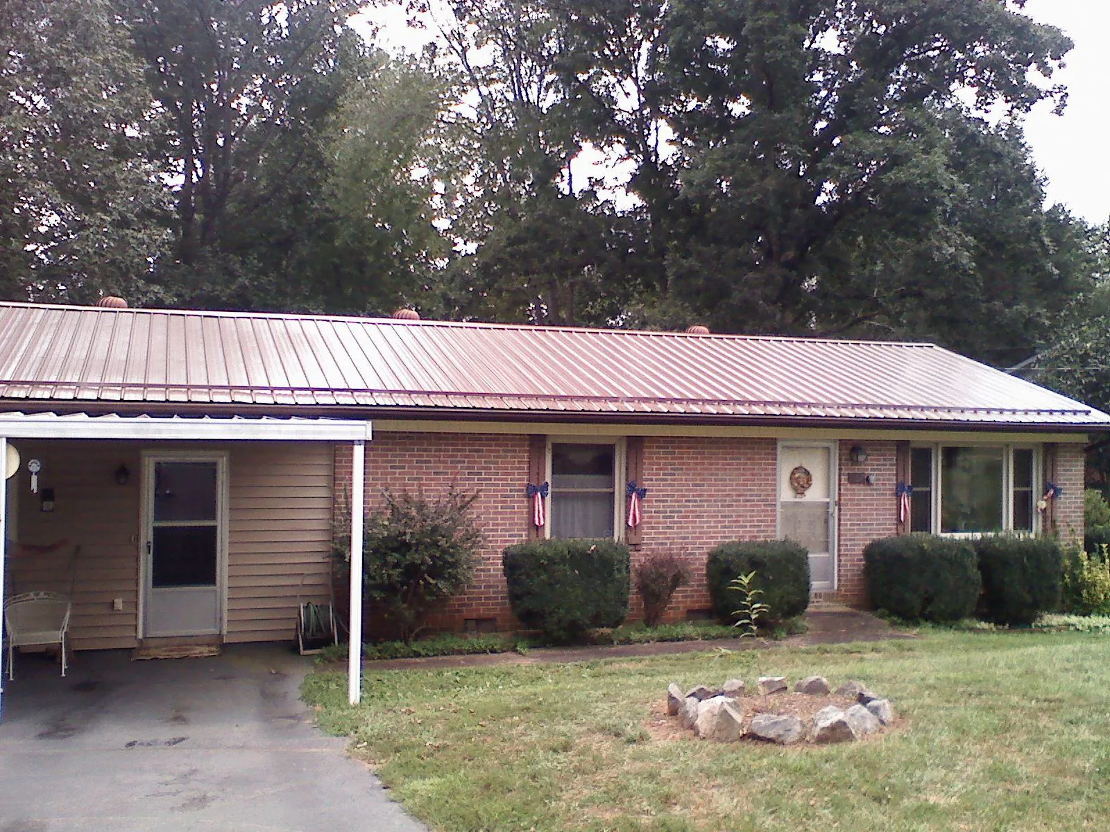 Bronze metal roof and carport on a brick ranch home — Roof Repair work by our crew in Myrtle Creek